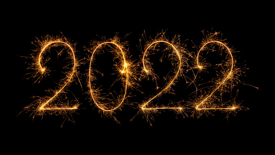 Happy New Year 2022 written with bengal fire, sparkler fireworks candle isolated on a black background. New Year dark background.